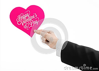 Valentine's Day and love theme: man's hand in a black suit holding a card in the form of a pink heart Stock Photo