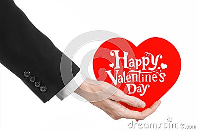 Valentine's Day and love theme: man's hand in a black suit holding a card in the form of a red heart Stock Photo