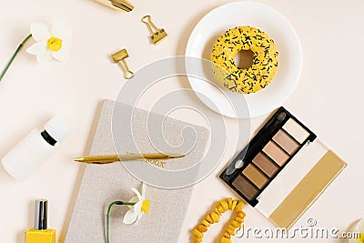 Valentine`s Day, Mother`s Day, spring concept with eye shadow, nail polish, donut, daffodils and notepad. View from above. A tre Stock Photo
