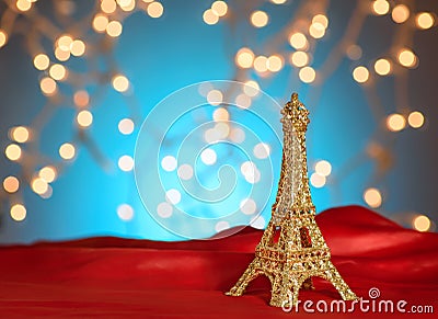Valentine`s Day in Paris. Christmas, New Year in Paris. Golden Eiffel Tower on bright red satin. Blurred Xmas lights background. Stock Photo