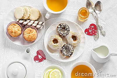 Valentine's day romantic Breakfast. Lemon green tea and sweets - banana muffins, cookies with caramel and nuts, donuts l Stock Photo