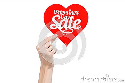 Valentine's Day and sale topic: Hand holding a card in the form of a red heart with the word Sale isolated on white background Stock Photo