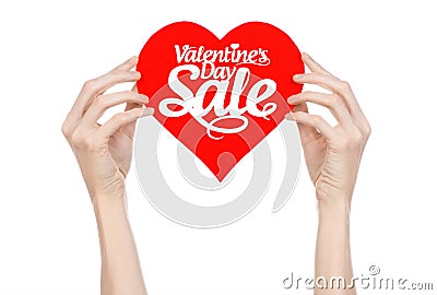 Valentine's Day and sale topic: Hand holding a card in the form of a red heart with the word Sale isolated on white background Stock Photo