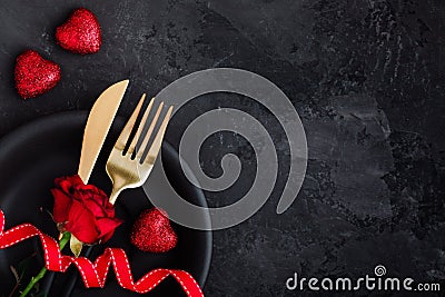 Valentine`s Day table setting with plate, gold knife, fork, red rose, ribbon and hearts Stock Photo