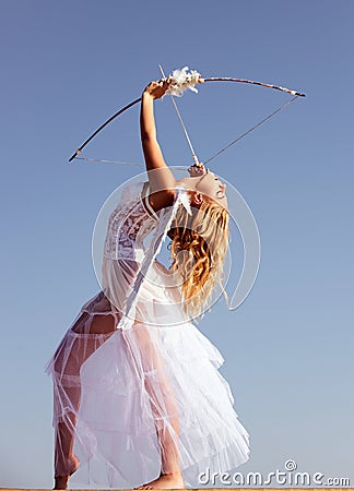 Valentines day. Angel cupid with bow and arrow. Woman in white dress. Portrait of sweet angelic girl. Stock Photo