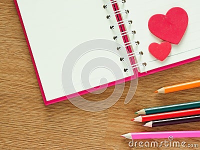 Valentines day background with red hearts, book for diary and color pencils on wood floor. Love and Valentine concept Stock Photo