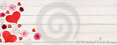 Valentines Day banner with corner border of hearts, flowers and decor against a white wood background with copy space Stock Photo