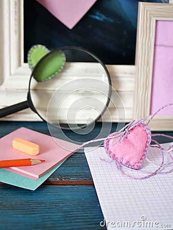 Valentines day, on a blue wooden table, an empty notebook, frames, pencils, felt hearts, bookmarks, preparation concept Stock Photo