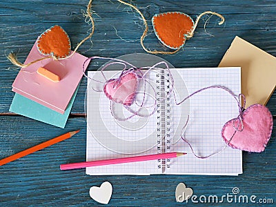 Valentines day, on a blue wooden table, an empty notebook, frames, pencils, felt hearts, bookmarks, preparation concept Stock Photo