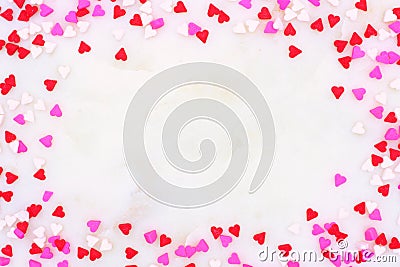 Valentines Day candy heart sprinkles frame over a white textured background Stock Photo