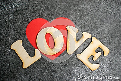 Valentines Day card background, red cute heart made of paper with decorative wooden word on dark background. Valentine Stock Photo