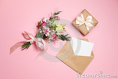 Valentines day composition: bouquet of flowers, gift box with ribbon bow, kraft envelope with greeting card lay at pink background Stock Photo