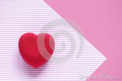 Valentines day concept. Pink velvet heart shaped cake on on a pink striped surface. Stock Photo