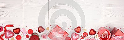 Valentines Day long banner border with red gifts and decorations over a white wood background with copy space Stock Photo