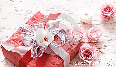Valentines day and mothers day concept, red gift box with bow and roses on light wooden background Stock Photo
