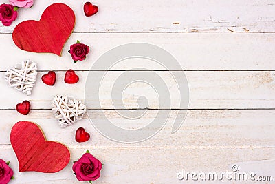 Valentines Day side border of hearts, flowers and decor against white wood Stock Photo