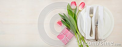 Valentines day table setting with pink tulips and a gift on white wooden background. Top view, copy space, banner Stock Photo