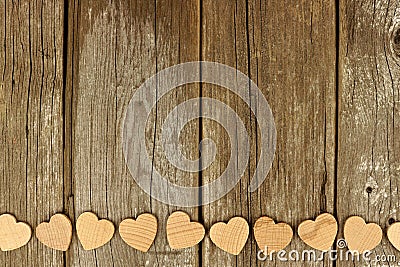 Valentines Day wooden hearts bottom border on rustic wood Stock Photo