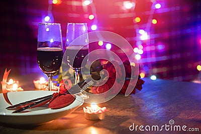 Valentines dinner romantic love concept Romantic table setting decorated with Red heart fork spoon on plate and couple champagne Stock Photo