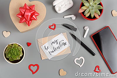 Valentines gift and BE MY VALENTINE card near hearts, succulent plants, earphones and smartphone Stock Photo