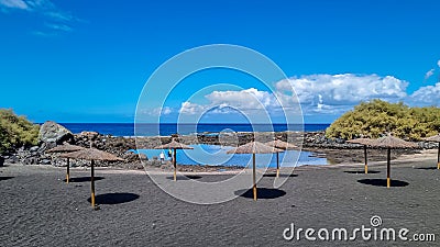 Valle Gran Rey - Scenic sea view on beach Playa Charco del Conde without people in Valle Gran Rey, La Gomera. Sun umbrellas Stock Photo