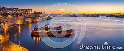 Valletta, Malta - Panoramic skyline view of Valletta and the Grand Harbor on a beautiful summer morning minutes before sunrise wi Editorial Stock Photo