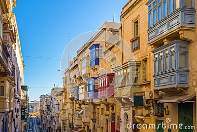 Valletta, Malta - Typical narrow street with colorful traditional windows and balconies and clear blue sky on a summer day Editorial Stock Photo