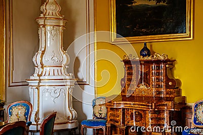 Valtice, Southern Moravia, Czech Republic, 04 July 2021: Castle interior with baroque wooden carved furniture, ceramic tiled stove Editorial Stock Photo