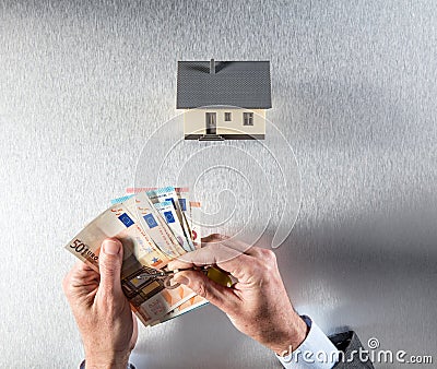 Valuation of building with hands of businessman, key and money Stock Photo