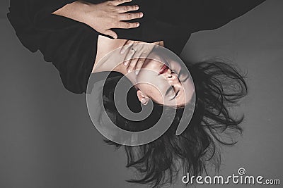 Vampire, gothic dark woman with large black cloth on gray backgr Stock Photo