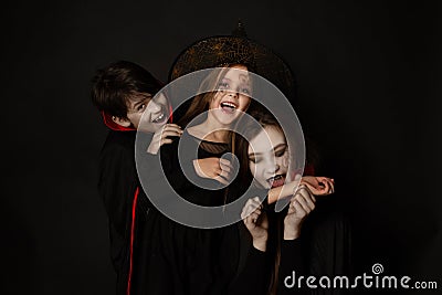 Vampires biting a witch, children in halloween costumes Stock Photo