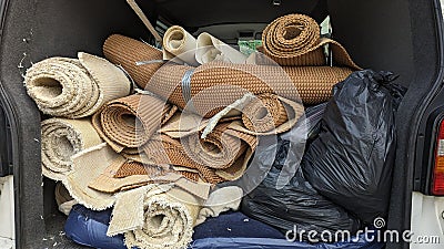 A van full of house clearance rolls of carpet and underlay Stock Photo