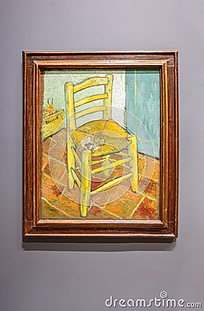Van Gogh's Chair with Pipe. The painting shows a rustic wooden chair with a simple woven straw seat on a Editorial Stock Photo