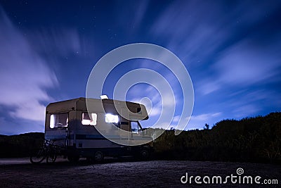 Van life concept. long exposure of recreational vehicle, also called camper, parked at night under the stars with clear sky and vi Stock Photo