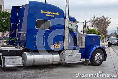 A Peterbuilt truck owned by Manuel Chacon Trucking making a wide turn in front of the Budweiser Brewery Gate 2. Editorial Stock Photo
