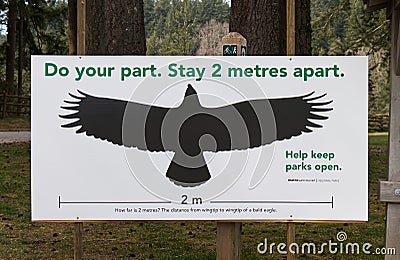 View of sign `Do your part. Stay 2 metres apart` in Capilano River Regional Park due to COVID-19coronavirus prevention Editorial Stock Photo