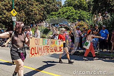 People are walking on Pacific Street with a huge sign Queers Against Climate Genocide during the Pride Parade Editorial Stock Photo