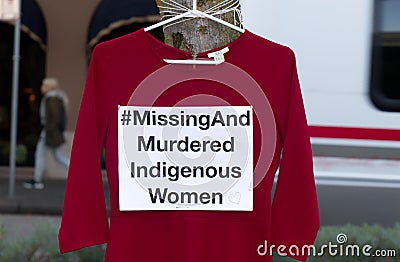 A red dress with text `Missing And Murdered Indigenous Women` is hanging on the tree. Editorial Stock Photo