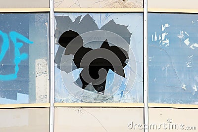 vandal broken windows in an abandoned shopping center building that stands unguarded. Stock Photo