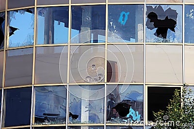 vandal broken windows in an abandoned shopping center building that stands unguarded. Stock Photo