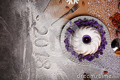 A vanilla cake with flowers on a plate. A New Year composition on a gray background. The inscription 2018 on a desk. Stock Photo