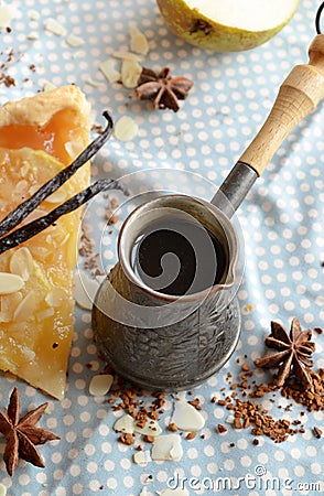 Vanilla coffee in the traditional cezve with a piece of pear cake Stock Photo