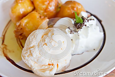 Vanilla ice cream with blurred out banana fritter Stock Photo