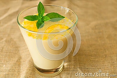Vanilla mousse or pudding with lemon zest and mint in a glass tall glass. Close-up Stock Photo