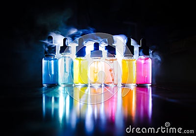 Vape concept. Smoke clouds and vape liquid bottles on dark background. Light effects. Useful as background or vape advertisement o Stock Photo