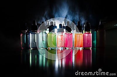 Vape concept. Smoke clouds and vape liquid bottles on dark background. Light effects. Useful as background or vape advertisement o Stock Photo