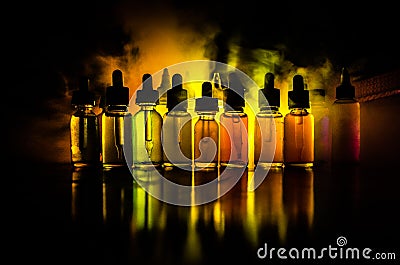 Vape concept. Smoke clouds and vape liquid bottles on dark background. Light effects. Useful as background or vape advertisement o Stock Photo