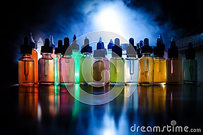 Vape concept. Smoke clouds and vape liquid bottles on dark background. Light effects. Useful as background or vape advertisement o Stock Photo
