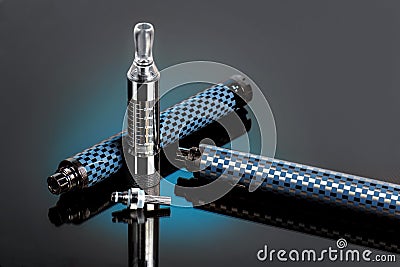 Vape, electronic cigarette exploded next to a conventional cigarette on a dark background. Stock Photo