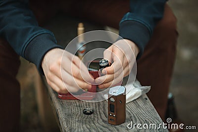 Vape. Electronic cigarette in male hands. Personal vaporizer. Stock Photo